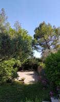 a garden with trees and a path with a bench at Villa Manoe in Draguignan