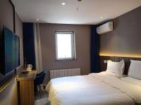 Una habitación de hotel con una cama y un televisor de pantalla plana. en 7Days Premium Jinzhou Railway Station Branch, en Jinzhou
