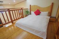 a bedroom with a white bed with a red pillow at No. 21 Jiaoxi Hot Spring Homestay in Jiaoxi