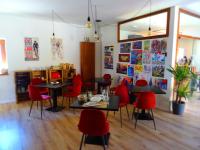 Un restaurante con sillas y mesas rojas en una habitación. en CicloLodge, en Lozoya