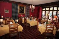 Un restaurante con mesas y sillas blancas y una lámpara de araña. en Cit'Hotel Marie Stuart, en La Roche-sur-Yon