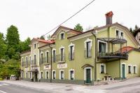 a large yellow building with white windows on a street at Rooms Herman in Pivka