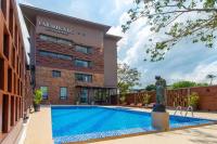 un hotel con piscina frente a un edificio en The Farm House Hotel Ranong, en Ranong