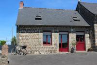 a brick building with red doors and a bike parked outside at Gîte La Loussaudrie in Pontmain
