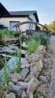 a pond in front of a house with a bridge at Pension am Silberberg in Gartz an der Oder