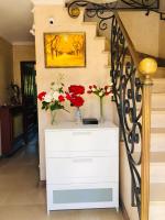 a white dresser with vases of flowers on it at Bondy chambre in Bondy