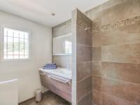 a white bathroom with a sink and a shower at Cosy villa with private pool in Emponse