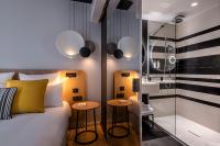 a bedroom with a bed and two stools next to a shower at Hôtel Villa KOEGUI Bayonne in Bayonne