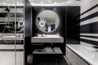 a bathroom with a sink and a tub and a mirror at Hôtel Villa KOEGUI Bayonne in Bayonne