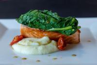 um prato branco com um pedaço de peixe com verduras em Best Western Plus Hotel Monza e Brianza Palace em Cinisello Balsamo