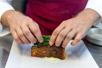 uma pessoa está fazendo uma sanduíche em um prato em Best Western Plus Hotel Monza e Brianza Palace em Cinisello Balsamo