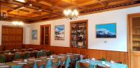 a dining room with tables and chairs and mountains at Hotel Des Alpes - Restaurant & Pizzeria in Airolo