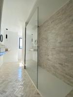 a glass door in a room with a stone wall at Villas de standing avec magnifique vue mer et piscines privées, Sagone in Sagone
