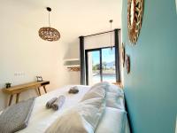 a bedroom with a bed with towels on it at Villas de standing avec magnifique vue mer et piscines privées, Sagone in Sagone