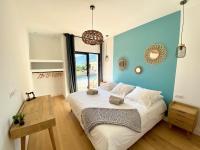 a bedroom with a large bed with a blue wall at Villas de standing avec magnifique vue mer et piscines privées, Sagone in Sagone