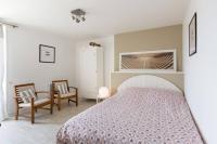a bedroom with a large bed and two chairs at Maison de vacances en pierre entre terre et mer in Pluduno