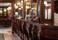 a bar in a restaurant with a wooden counter at Hotell Stinsen in Hallsberg