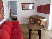 a living room with a red couch and a table at Casa Sol in Vejer de la Frontera