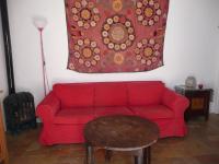 a red couch in a living room with a table at Casa Sol in Vejer de la Frontera