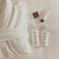 a towel and two bottles of lotion next to a towel at Hôtel Villa KOEGUI Bayonne in Bayonne