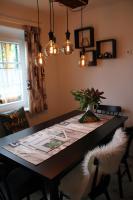 a dining room table with a vase of flowers and lights at Buchschneider - Ferienhaus Maier - Landhof in Schwarzautal