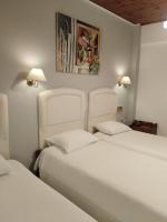 2 camas en una habitación con 2 camas blancas en Kouros Hotel, en Delfos