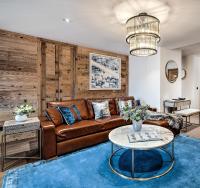 a living room with a brown couch and a table at Hôtel La Sivolière in Courchevel