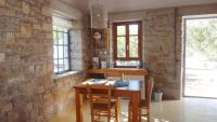 a kitchen with a wooden table and a stone wall at Kastraki Art Houses in Kousounárion