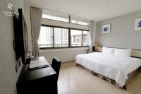 a bedroom with a bed and a desk and a window at Talmud Hotel Taichung in Taichung
