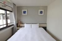 a bedroom with a white bed and a window at Talmud Hotel Taichung in Taichung