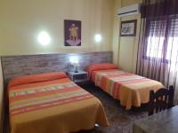 A bed or beds in a room at Hostal Virgen Del Rocío