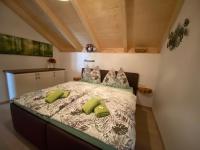 A bed or beds in a room at Apartments Edelweiß & Enzian - Gästehaus zum Fuchs