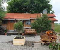 a garden with a house with a wheelbarrow in front of it at Chrom Ranch Reiterhof in Memmingen