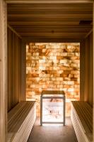 a room with two benches in front of a stone wall at Aries Hotel & SPA Wisła in Wisła