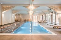 a large pool with blue water in a room with windows at Aries Hotel & SPA Wisła in Wisła