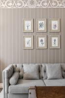 a living room with a couch and framed drawings on the wall at Aries Hotel & SPA Wisła in Wisła