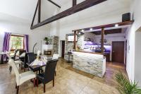 uma sala de estar com mesa e cadeiras e um bar em Wellness Penzion Life em Číměř