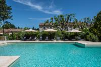 a swimming pool with chairs and umbrellas at Hôtel Mas Valentine in Saint-Rémy-de-Provence