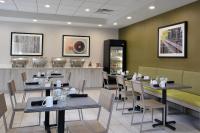 Un restaurante con mesas y sillas y un mostrador. en Holiday Inn Raleigh Durham Airport by IHG, en Morrisville