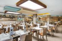 a restaurant with tables and chairs and a large window at Hotel Riu Festival in Playa de Palma