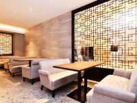 a restaurant with tables and chairs and a wall with tiles at ART Hotel Oita in Oita