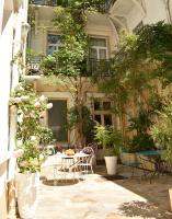 Un patio con una mesa y sillas frente a un edificio. en Hôtel Henri IV, en Tarbes