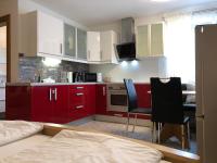 a kitchen with red cabinets and a table and chairs at Ferienwohnung EG Familie Meinschad in Rietz