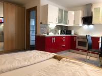 a kitchen with red cabinets and a bed in a room at Ferienwohnung EG Familie Meinschad in Rietz