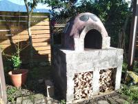 an outdoor oven is filled with fire wood at Celine&#39;s B&amp;B in Fenglin