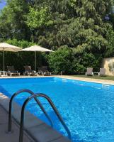 a large swimming pool with chairs and umbrellas at Brit Hotel Europ Bergerac in Bergerac
