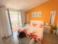 a bedroom with a bed with an orange wall at Apartment Beach in Makarska