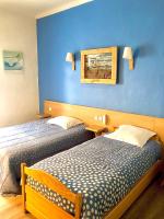 a hotel room with two beds and a blue wall at Hôtel Colisée-Verdun Centre Gare Saint-Roch in Montpellier