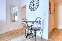 une salle à manger avec une table, des chaises et une horloge murale dans l&#39;établissement Romantic and new apartment in the famous Rue Meynadier in the supercentre of Cannes, à Cannes