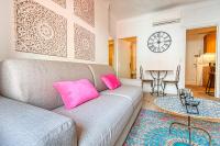 - un salon avec un canapé gris et des oreillers roses dans l&#39;établissement Romantic and new apartment in the famous Rue Meynadier in the supercentre of Cannes, à Cannes